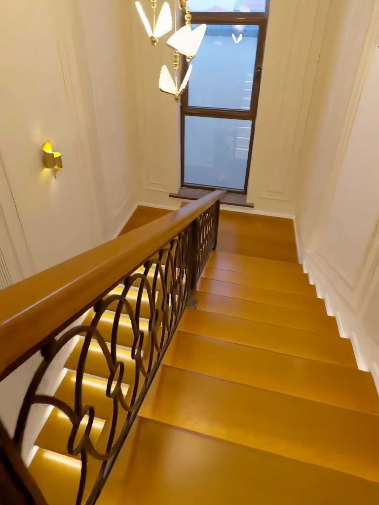 پله و هندریل چوب راش رنگ عسلی با نورپردازی مدرن