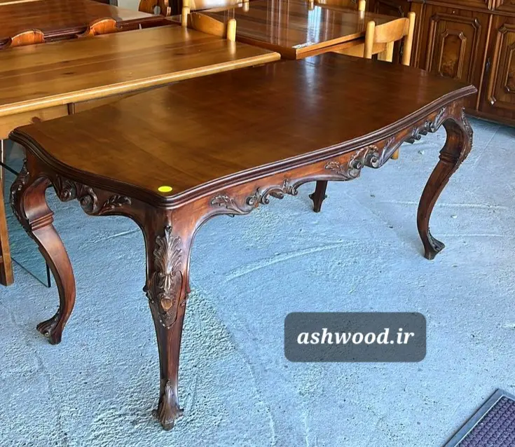 میز غذاخوری 10 نفره چوبی لاکچری با منبت‌کاری دست‌ساز ظریف بر روی پایه‌های مجلل، در یک سالن پذیرایی مدرن-کلاسیک